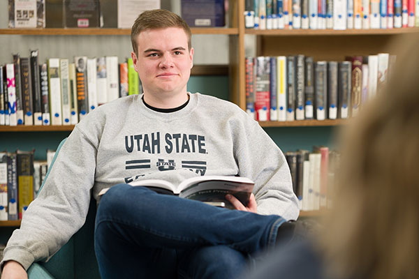student at llc in front of bookshelves