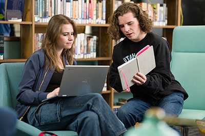 students on laptop and reading in the LLC